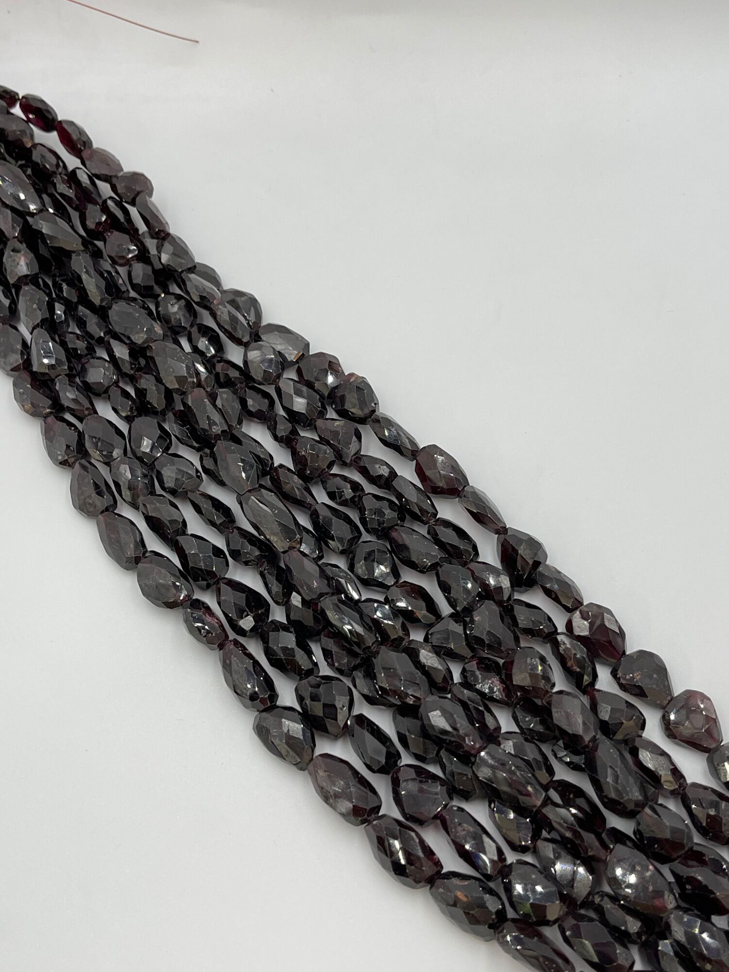 Red garnet faceted oval shape. รูปไข่เหลี่ยมเพชรพลอยสีแดง