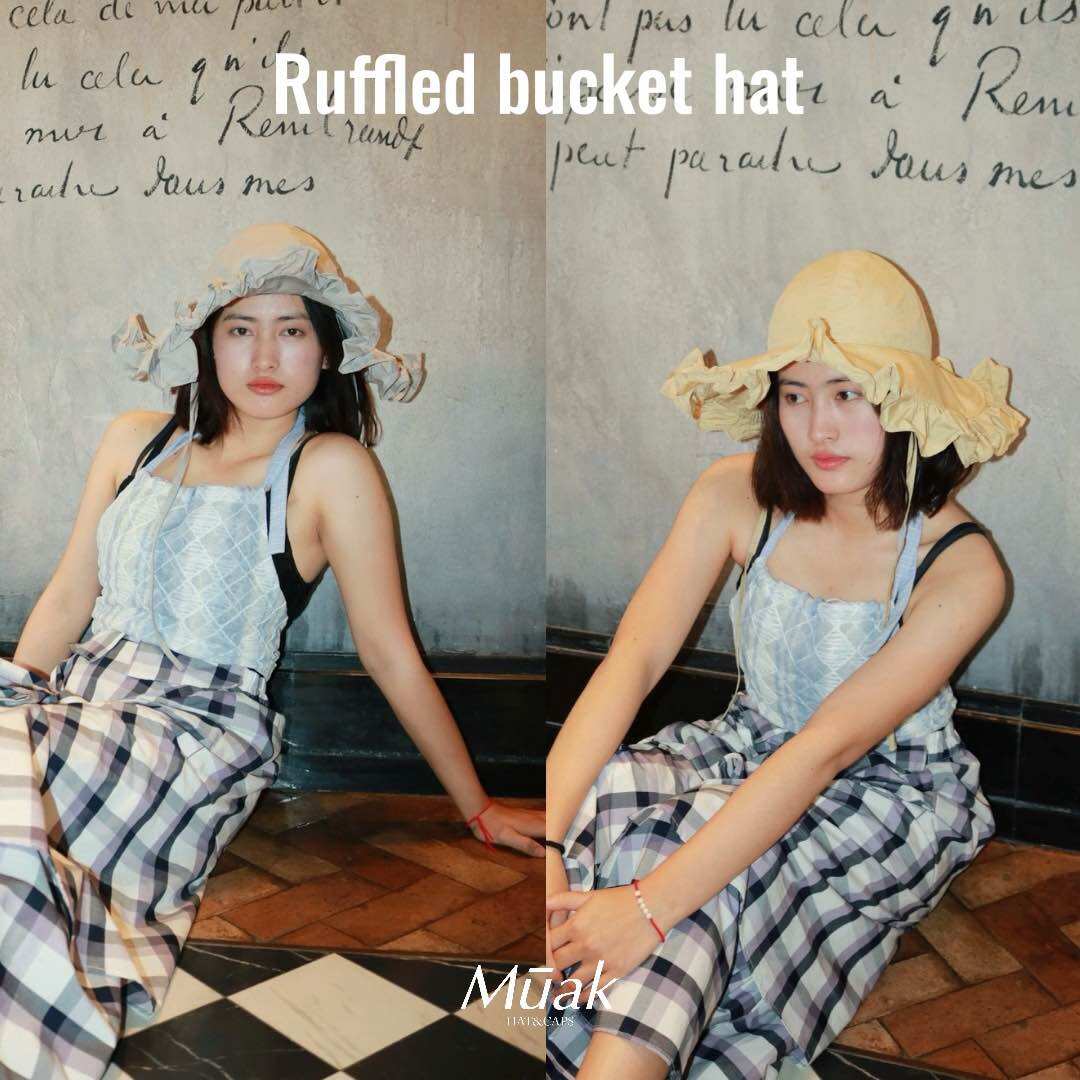 Mūak - Ruffled Bucket Hat, a Special Design Hat That Adds a Unique Touch. Ruffles Around the Brim of the Hat Give It a Sweet, Soft Look and a Vintage Charm. ราคา 1,032 บาท*ส่งฟรี