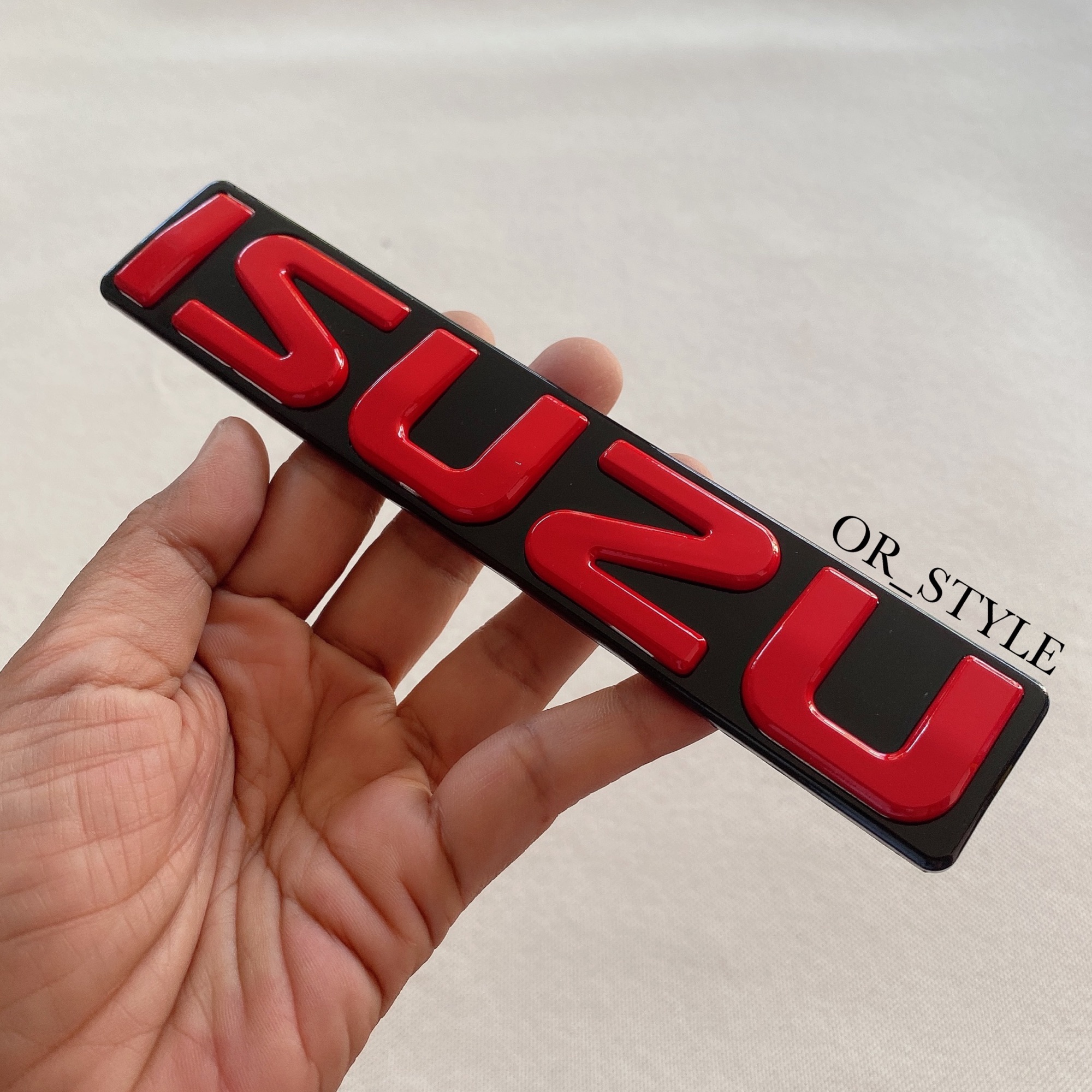 โลโก้ ISUZU ติดกระจัง 2007-2011 สีแดงพื้นดำ (ไซส์เล็ก) ขนาด 17.4x3.4cm